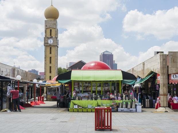 Walkway between shopfronts with the clock tower behind