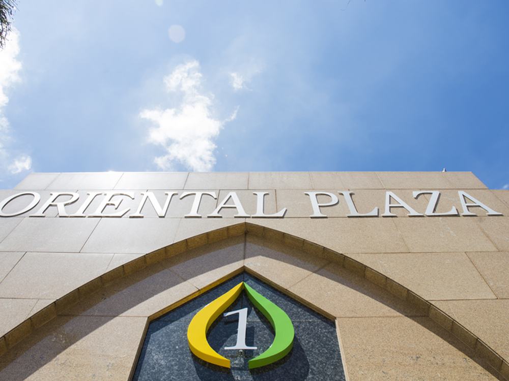 Oriental Plaza lettering on the sandstone facade against a blue sky